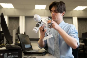 Computer Science student with robot and laptop