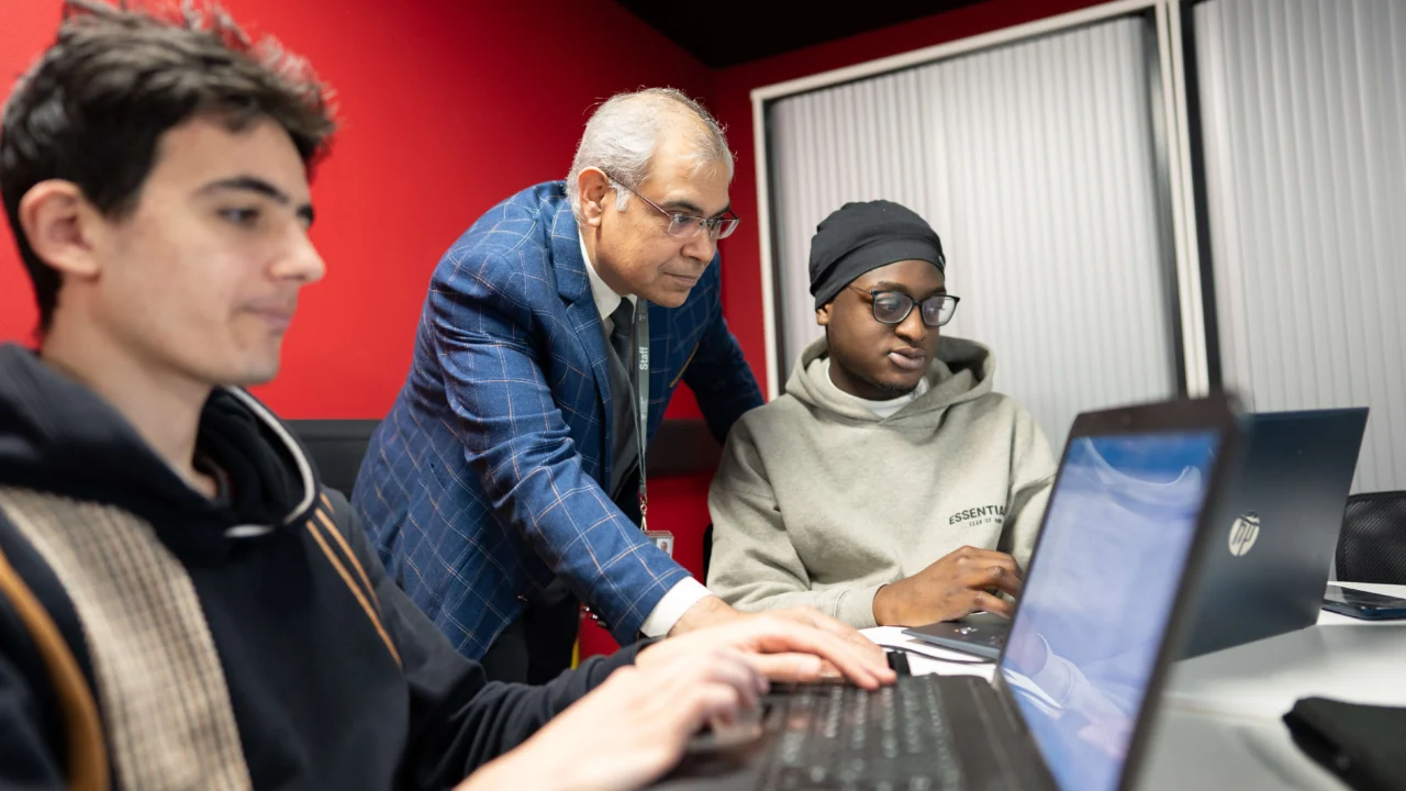 Computer Science student in class on laptop with tutor